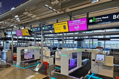 passengers using self-service baggage kiosks before departure