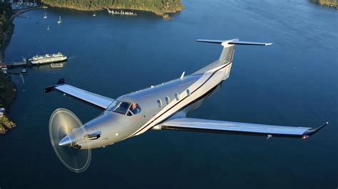 Pilatus PC-12 taking off from rural grass airstrip