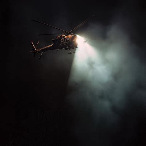 police helicopter with spotlight during night pursuit