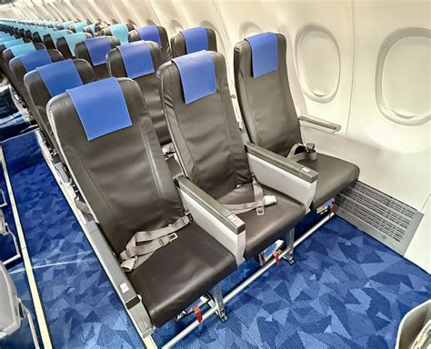 premium economy aircraft cabin with wider seats and larger armrests on long haul flight