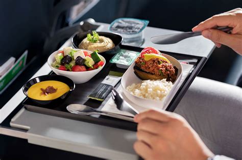 premium economy airline meal service with ceramic dishware and upgraded presentation