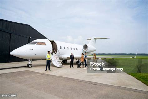 private jet on tarmac with passengers boarding for charter flight under sunset sky