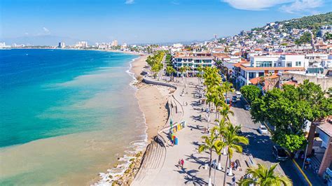 puerto vallarta beach and cityscape with incoming american airlines flight