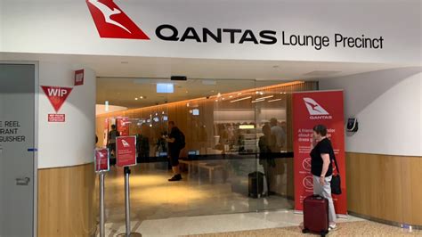 Qantas aircraft at Brisbane Airport terminal with boarding gates and airbridges