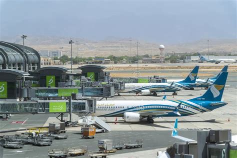Qatar Airways and Oman Air aircraft parked side by side at Hamad International Airport