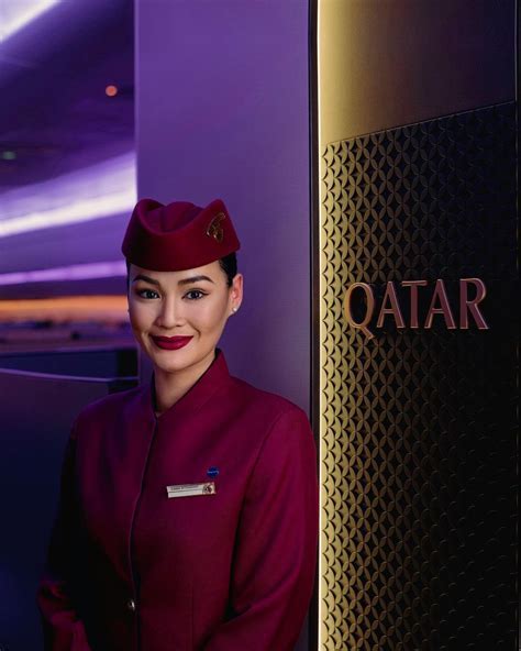 Qatar Airways Cabin Crew attending to passengers in a modern aircraft cabin