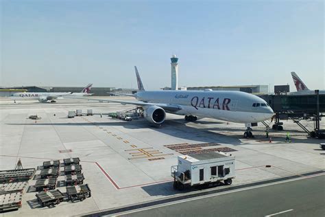 Qatar Airways ground crew managing logistics at a busy airport terminal