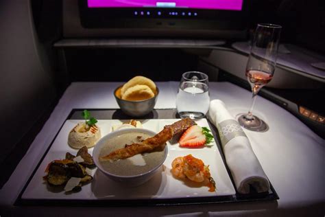 Qatar Airways Qsuite gourmet dining service with plated multi-course meal