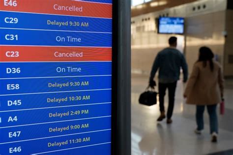 Reagan National Airport flight status boards showing dozens of cancellations