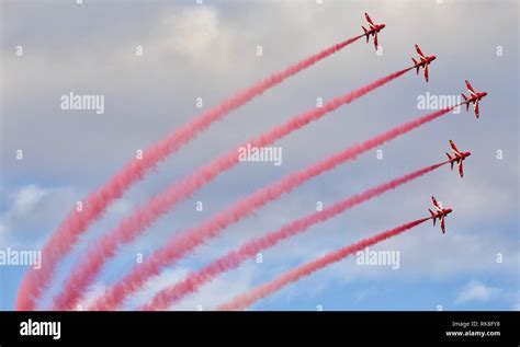 Red Arrows in diamond formation with red smoke trails during an airshow