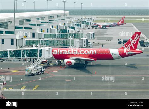 regional airport in malaysia with small jets parked and passengers boarding