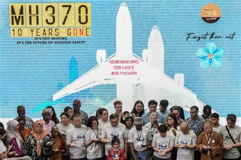 relatives of MH370 passengers holding memorial photos during remembrance ceremony