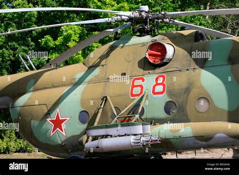 Russian Mi-24 Hind helicopter flying over forested terrain with rocket pods armed