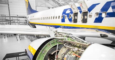 Ryanair aircraft under maintenance at nighttime, airport floodlights shining
