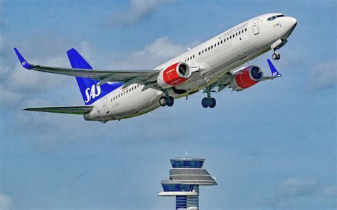 SAS aircraft taking off from snowy Arlanda airport runway