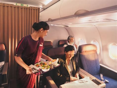 singapore airlines cabin crew welcoming passengers premium class entrance