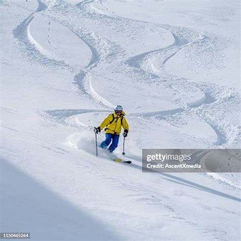 Skier descending powder slope with airport runway visible in the distance