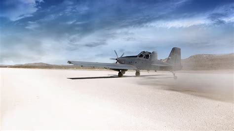 Sky Warden aircraft performing low-altitude flight over desert terrain with external missile loadout