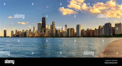 skyline of chicago viewed from lakefront at sunset with airplane in sky