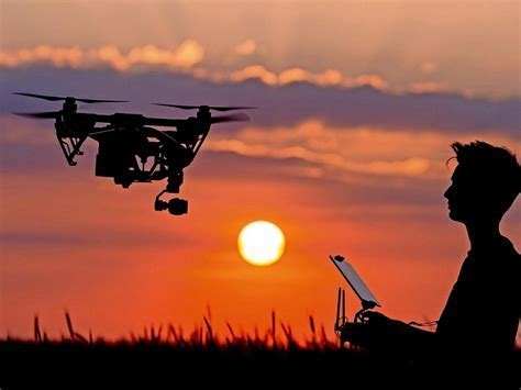 smiling person holding budget drone at sunset over park trail