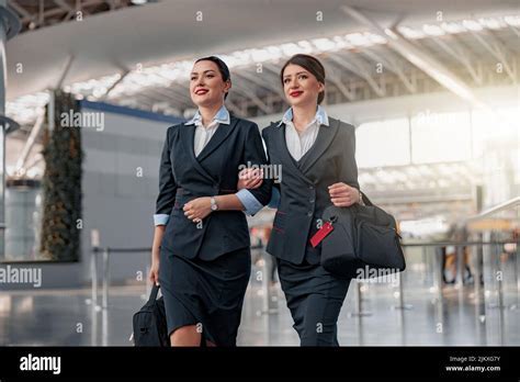smiling southwest flight attendants walking through airport concourse in uniform