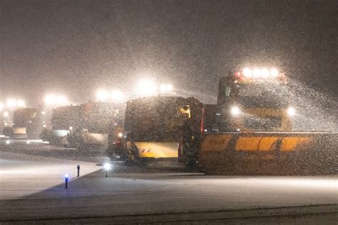 snow crews at schiphol airport battling heavy snow with plows and blowers