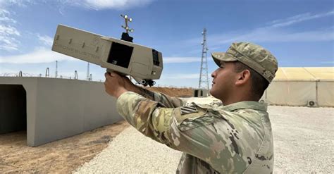 soldier using Dronebuster system at military base perimeter
