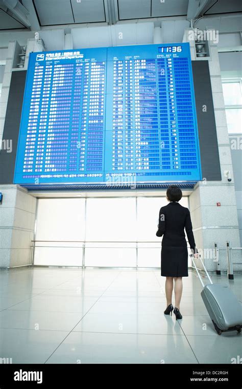 solo business traveler at airport checking departure board