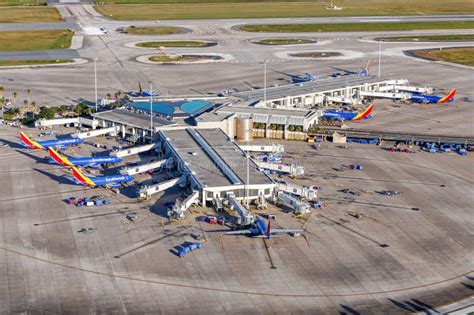 southwest aircraft landing at orlando international airport in front of terminal c with sunrise backdrop