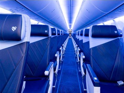 Southwest Airlines cabin interior showing assigned seat signage and boarding passengers aisle view