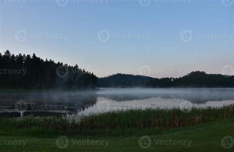 steam fog rising off a lake on a cold morning with orange horizon