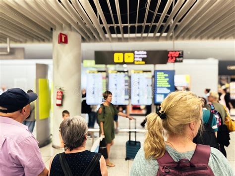 stranded passengers checking delay updates on screens at Chicago O’Hare International Airport
