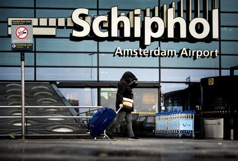 stranded passengers queuing for rebooking desks at Amsterdam Schiphol Airport