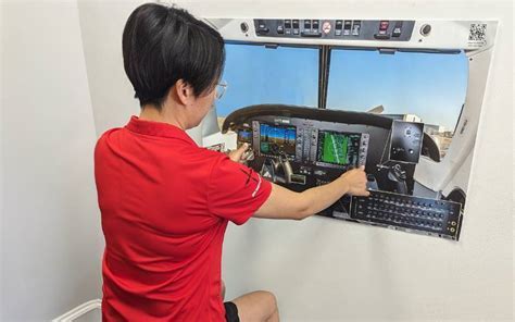 Student chair-flying with a printed cockpit layout on a desk