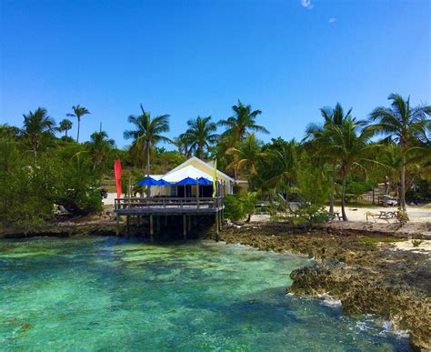 sunset over Green Turtle Cay in Abaco with tourists enjoying a beach bar