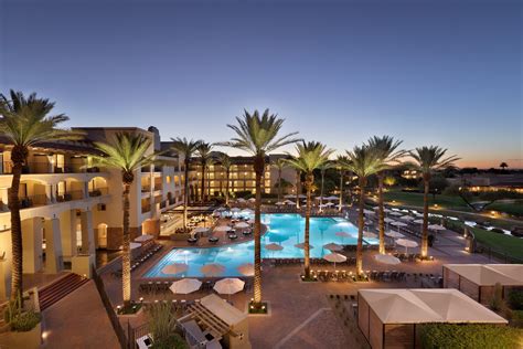 sunset view of the Fairmont Scottsdale Princess luxury resort with palm trees and pool reflections