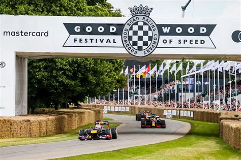 supercars at Goodwood Festival of Speed with crowd and flags
