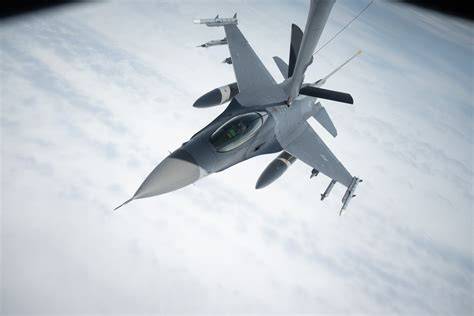 supersonic F-16 Fighting Falcon flying above clouds at high altitude