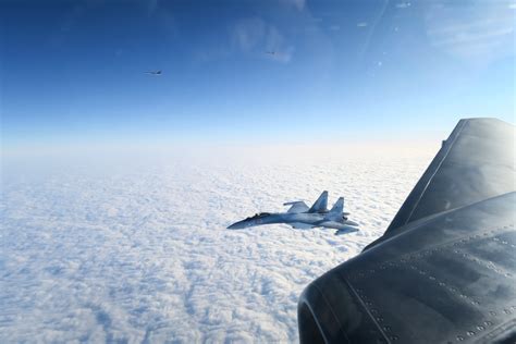 swedish fighter jet escorting nato reconnaissance aircraft over baltic sea