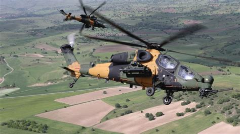 TAI T129 ATAK hovering above rugged mountainous terrain