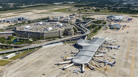 Tampa International Airport terminal exterior with palm trees and JetBlue plane