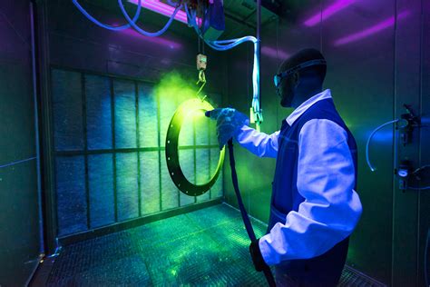 technician performing liquid penetrant test on aircraft wing section with fluorescent dye