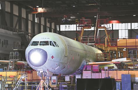 Technicians testing electrical systems in an A321 fuselage at the Tianjin production facility