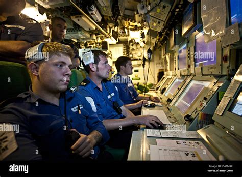 technicians upgrading sonar electronics inside nuclear submarine control room