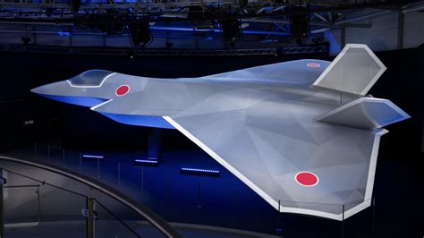 Tempest stealth fighter model from GCAP displayed in Tokyo with UK, Italian, and Japanese flags in the background