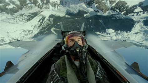 Top Gun Maverick flying F-18 over snowy terrain