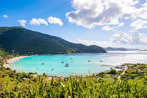 tortola beach with anchored sailboats and lush green hills
