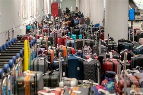 Tourists waiting with luggage at congested Faro airport terminal