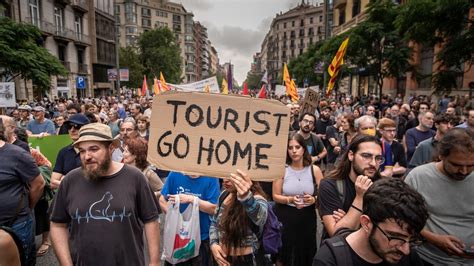 tourists walking through barcelona under banner demanding respectful travel
