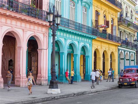 tourists walking through Old Havana streets with colorful colonial buildings